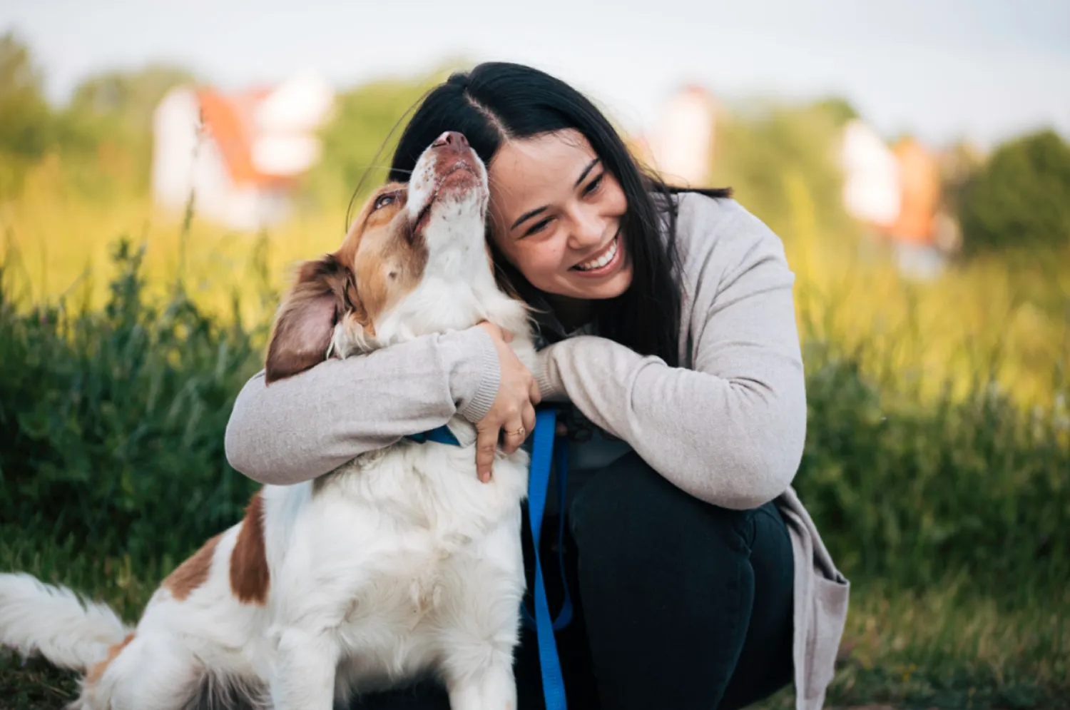 Tutora abrazando a su perro en el parque